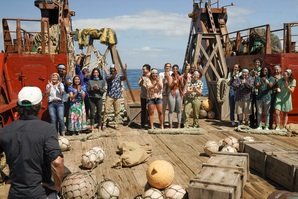 Castaways stand on a boat as the game gets ready to start