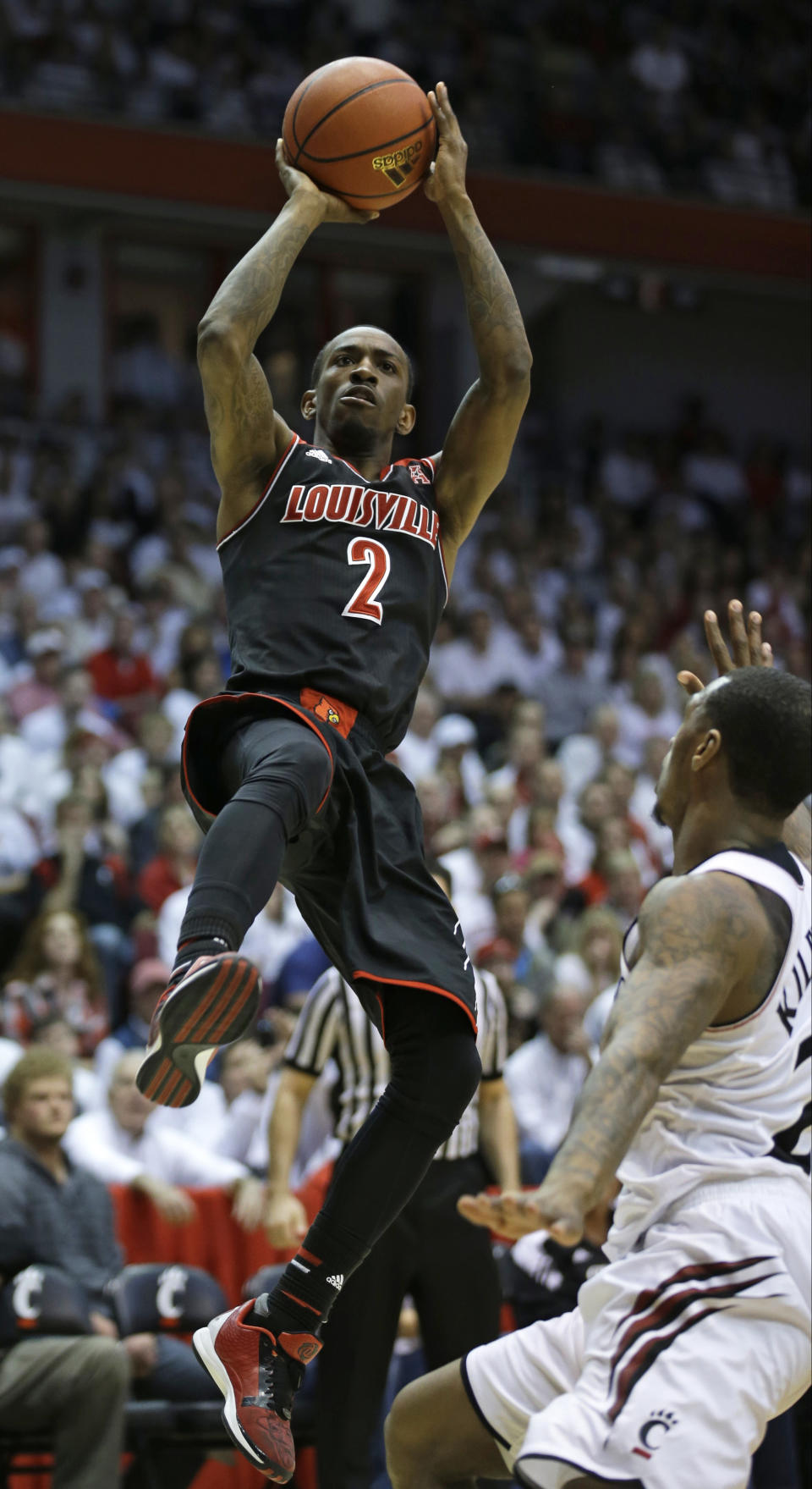 FILE - In this Feb. 22, 2014 file photo, Louisville guard Russ Smith (2) shoots over Cincinnati guard Sean Kilpatrick in the second half of an NCAA college basketball game in Cincinnati. Smith was selected to The Associated Press All-America team, released Monday, March 31, 2014. (AP Photo/Al Behrman, File)