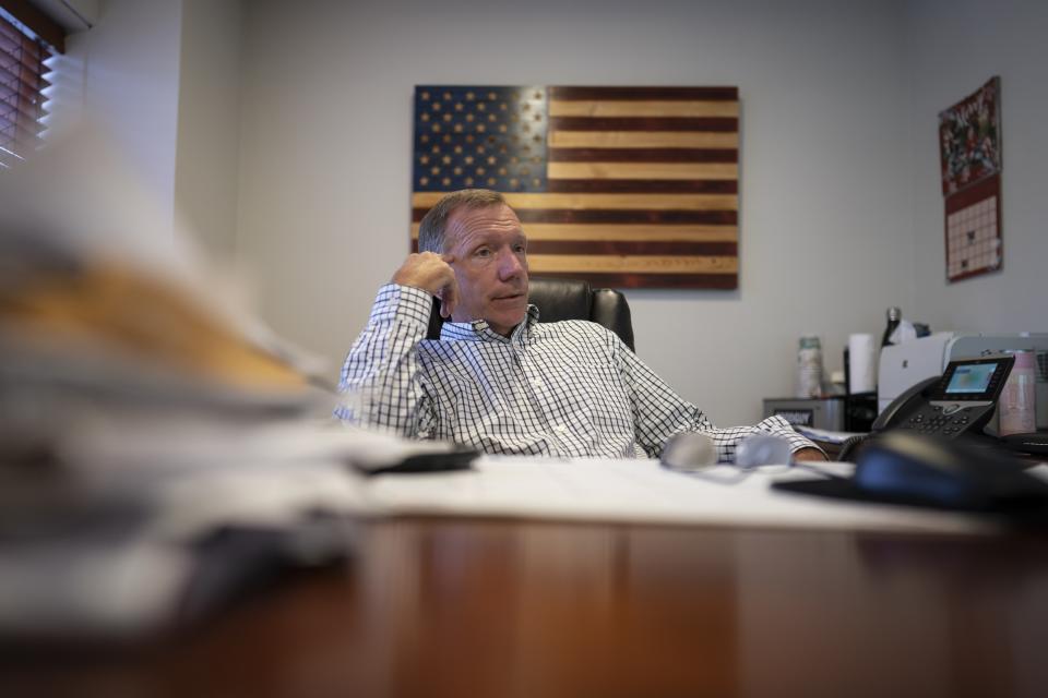 Retired NYPD Officer Ken Winkler, sits in his office on Tuesday, Aug. 3, 2021, in New York. Winkler helped coordinate the New York Police Department Emergency Service Unit response on-scene at the World Trade Center on Sept. 11, ducking behind a truck to escape the debris when the south tower collapsed. "It went from a clear day to various shades of gray and black … from kind of organized chaos to just chaos," recalls Winkler. (AP Photo/Wong Maye-E)