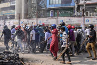 A group of protestors walk with wooden sticks during a clash with another group after Friday prayers at Baitul Mokarram mosque in Dhaka, Bangladesh, Friday, March 26, 2021. Witnesses said violent clashes broke out after one faction of protesters began waving their shoes as a sign of disrespect to Indian Prime Minister Narendra Modi, and another group tried to stop them. Local media said the protesters who tried to stop the shoe-waving are aligned with the ruling Awami League party. The party criticized the other protest faction for attempting to create chaos in the country during Modi’s visit. (AP Photo/Mahmud Hossain Opu)
