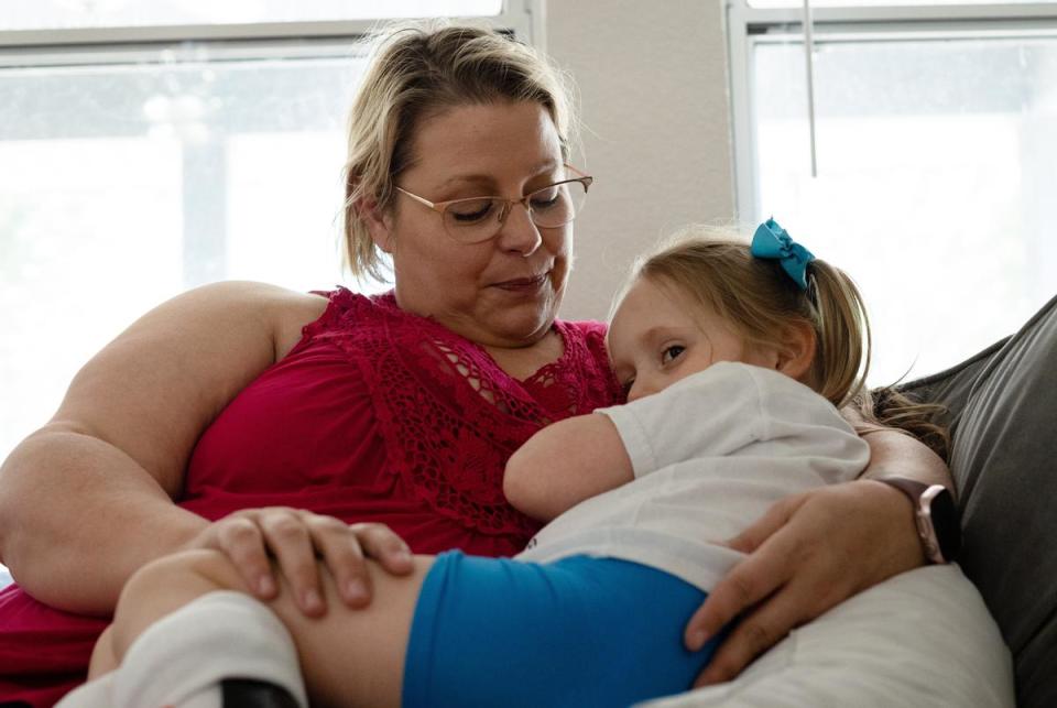 Jodi Whites and her daughter, Amelia, sit together after lunch in their home in New Braunfels, on July 27, 2023. “Sometimes people will tell me ‘Oh, she doesn’t look sick’,” said Whites. “I tell them, ‘We paid extra for that’. No, really, this is what four years of Medicaid does for us. If we skip services for too long, the greater the chance she will relapse.”