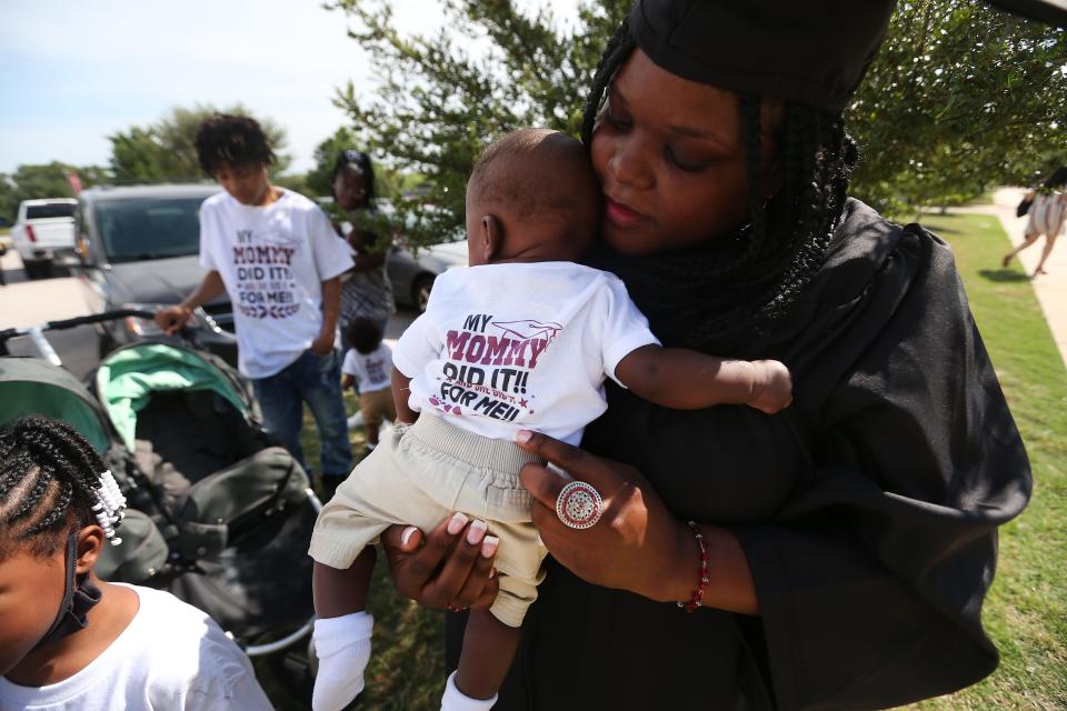 As she gets ready to receive her diploma at the Austin Community College graduation ceremony on May 13, Shilda Fresch holds a son she is in the process of adopting. The family is now working on opening up a new business.