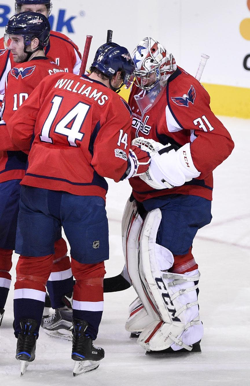 Washington Capitals right wing Justin Williams (14) celebrates a win over the Philadelphia Flyers with goalie Philipp Grubauer (31), of Germany, after an NHL hockey game, Sunday, Jan. 15, 2017, in Washington. (AP Photo/Nick Wass)