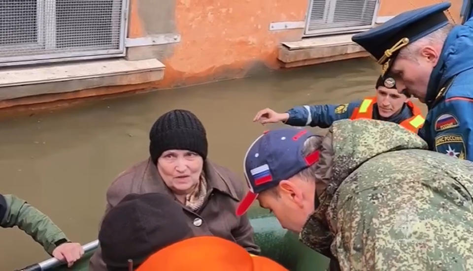 In this grab taken from a video released by the Russian Emergency Ministry Press Service on Sunday, April 7, 2024,Russian Emergency Situations Minister Alexnader Kurenkov, right speaks to a woman as emergency workers evacuate local residents with their pets after part of a dam burst causing flooding, in Orsk, Russia. State media say Russia’s government has declared the situation in flood-hit areas in the Orenburg region a federal emergency. The floods, caused by rising water levels in the Ural River, forced over 4,000 people, including over 800 children, to evacuate, the regional government said. (Russian Emergency Ministry Press Service via AP)