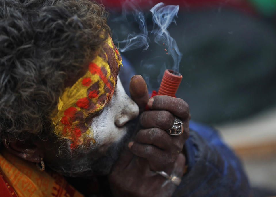 A Hindu holy man smokes marijuana during Shivaratri festival at the premises of Pashupatinath temple in Kathmandu, Nepal, Friday, Feb. 21, 2020. Hindu holy men were joined by devotees and the public Friday at a revered temple in Kathmandu where they lit up marijuana cigarettes during an annual festival despite prohibition and warning by authorities. Hindu holy men were joined by devotees and the public Friday at a revered temple in Kathmandu where they lit up marijuana cigarettes during an annual festival despite prohibition and warning by authorities. “There is a ban on smoking marijuana but at the same time it is centuries-old tradition which we have to respect,”said police officer Suman Khadka adding there was no arrests made Friday. (AP Photo/Niranjan Shrestha)