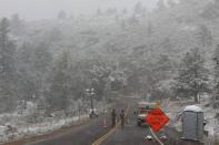 <p>Les membres de la Garde nationale du Colorado surveillent un barrage routier menant à l'incendie de Cameron Peak alors que la neige tombe un jour après que la région a subi des records de chaleur.</p>