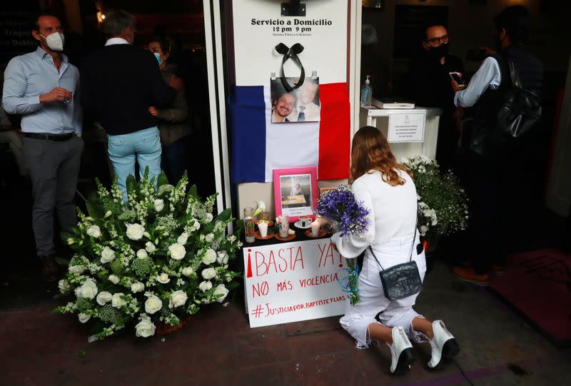 A member of the French community living in Mexico places flowers at an altar outside a restaurant owned by French businessman Baptiste Jacques Daniel Lormand after he was found murdered, in Mexico City