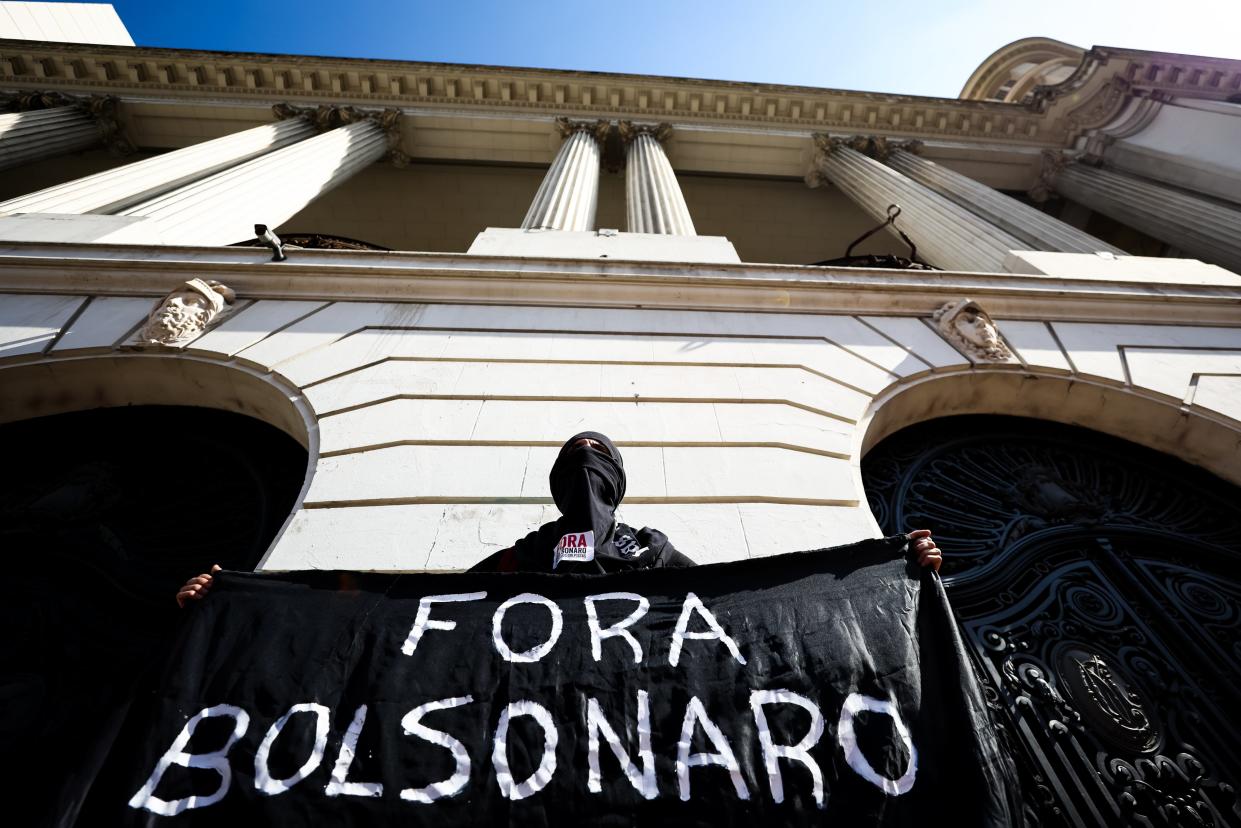 <p>A demonstrator wearing black cloches holds a banner that reads “Bolsonaro out” during a anti-Bolsonaro protest on 29 May, 2021 in Rio de Janeiro, Brazil. </p> (Getty Images)