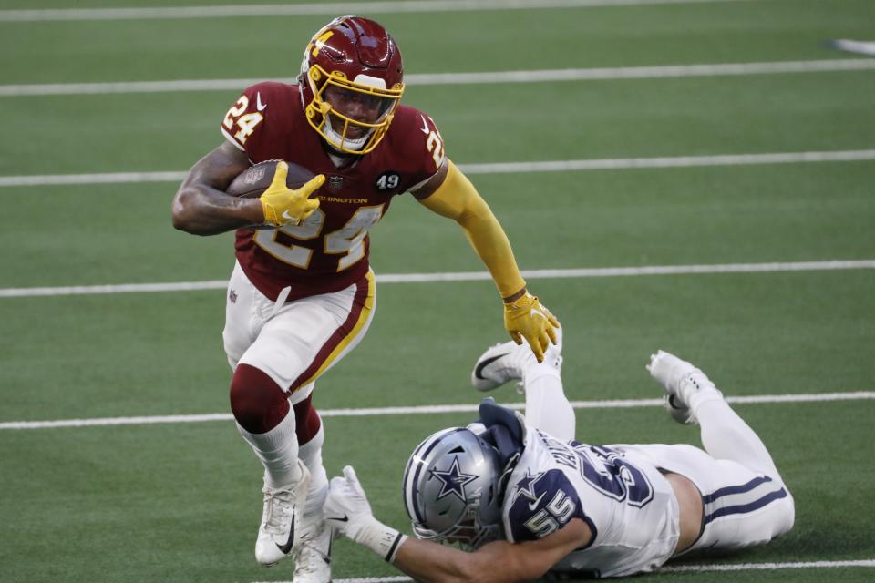 Washington Football Team running back Antonio Gibson (24) escapes a tackle attempt by Dallas Cowboys linebacker Leighton Vander Esch (55) in the first half of an NFL football game in Arlington, Texas, Thursday, Nov. 26, 2020. (AP Photo/Roger Steinman)