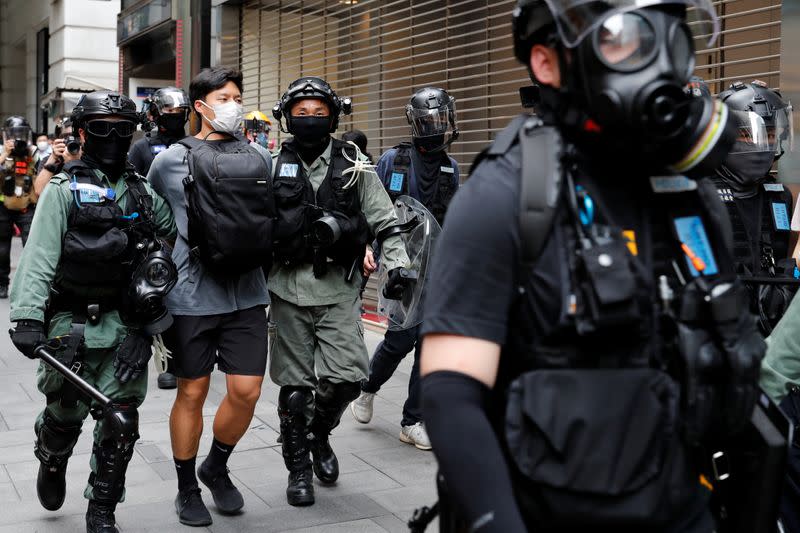 Riot police officers detain an anti-government demonstrator during a protest at Central District against the second reading of a controversial national anthem law in Hong Kong