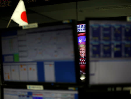 FILE PHOTO - U.S. Republican presidential nominee Donald Trump is seen between monitors on TV news at a foreign exchange trading company in Tokyo, Japan, November 9, 2016. REUTERS/Toru Hanai/File Photo