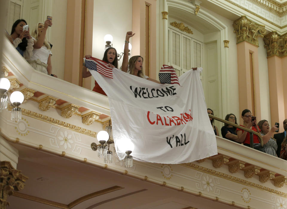 Demonstrators unfurl a banner to protest the state Senate's passage of a measure to crack down on doctors who sell fraudulent medical exemptions for vaccinations, in Sacramento, Calif., Wednesday, Sept. 4, 2019. Lawmakers sent the bill to Newsom on Wednesday but he said he wants last-minute changes. (AP Photo/Rich Pedroncelli)