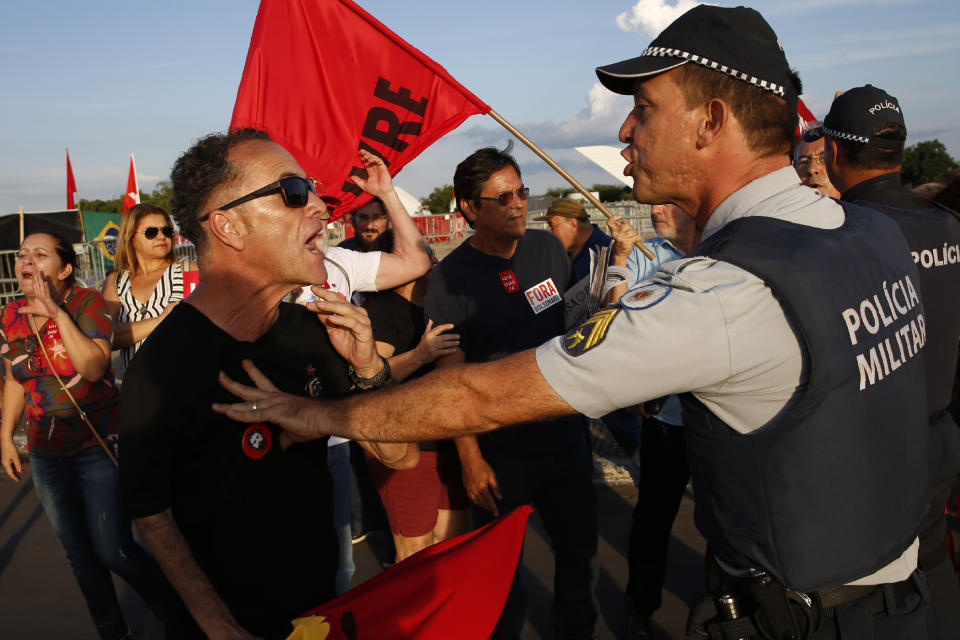 Police attempt to defuse a situation between supporters of jailed former President Luiz Inacio Lula da Silva and President Jair Bolsonaro, as both groups keep vigil outside the Supreme Court in Brasilia, Brazil, Thursday, Nov. 7, 2019. Brazil’s highest court reached a narrow decision that could release almost 5,000 inmates who are still appealing their convictions, including jailed former President Luiz Inácio Lula da Silva. The country’s Supreme Court decided on a 6-5 vote Thursday night that a person can be imprisoned only after all appeals to higher courts have been exhausted. (AP Photo/Eraldo Peres)