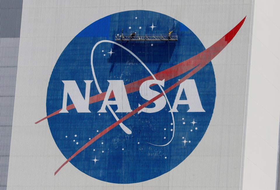 FILE PHOTO: Workers pressure wash the logo of NASA on the Vehicle Assembly Building, in Cape Canaveral