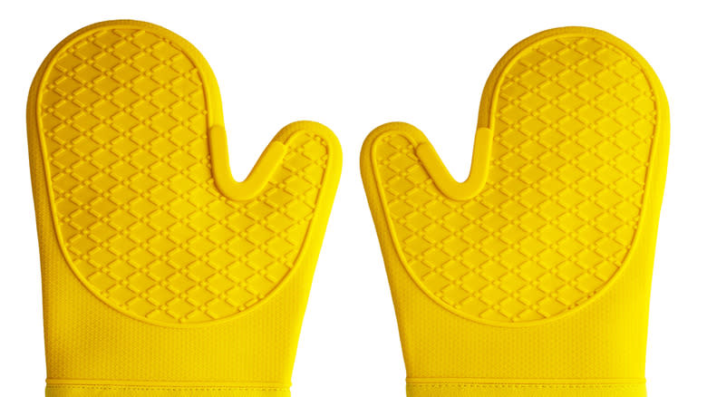 two yellow silicone oven mitts