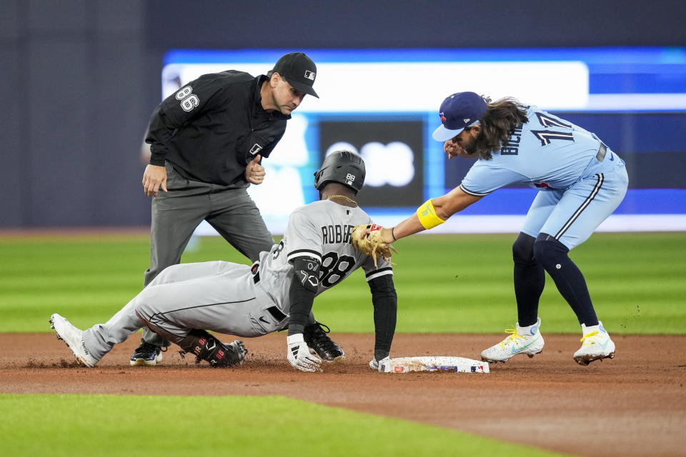 Toronto Blue Jays shortstop Bo Bichette (11) tags out Chicago White Sox's Luis Robert Jr. (88) at second base during the first inning of a baseball game in Toronto, Wednesday, April 26, 2023. (Andrew Lahodynskyj/The Canadian Press via AP)