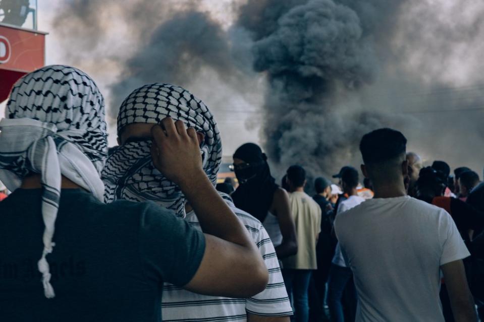 A young Palestinian man has his face shielded with a kuffiyeh during a confrontation near Beit El, a settlement considered illegal under international law, in the West Bank city of al-Bireh, on Oct. 13. The kuffiyeh, a traditional headdress, serves as a symbol of Palestinian identity.<span class="copyright">Maen Hammad</span>