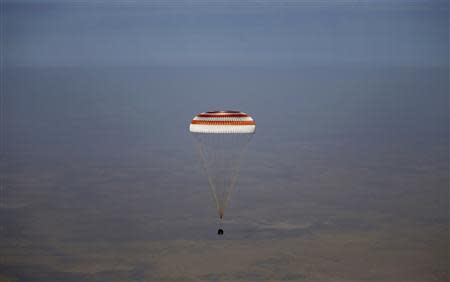 A Russian Soyuz TMA-08M spacecraft carrying Expedition 36 Commander Russian cosmonaut Pavel Vinogradov and Flight Engineers, US NASA astronaut Chris Cassidy and Russian cosmonaut Alexander Misurkin descends beneath a parachute just before landing some 146 km southeast of the town of Zhezkazgan in Kazakhstan, September 11, 2013. REUTERS/Maxim Shipenkov/Pool