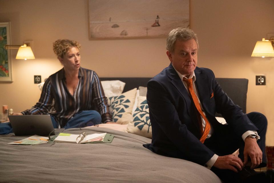 Alex Kingston and Hugh Bonneville sit on a bed in a scene from Douglas is Cancelled
