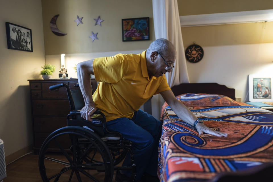 Alex Morisey lifts himself out of his wheelchair in his room at a nursing home in Philadelphia, on Wednesday, Feb. 15, 2023. His physical therapist just told him he'll use a wheelchair all the days he has left. He hasn't been outside since before the new year dawned, can't hear a soft Mexican ballad over the thunder of his roommate's TV, and when he checks his bank account, there isn't enough to order a replacement for his tattered pants. (AP Photo/Wong Maye-E)