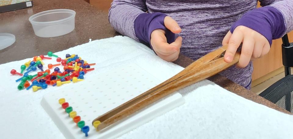 Amanda Zimmerman's daughter practices her fine motor skills at home in Northern Michigan. Amanda and her husband have mostly paid out-of-pocket for therapies that address their daughter's issues, which include PTSD and an expressive communication disorder.