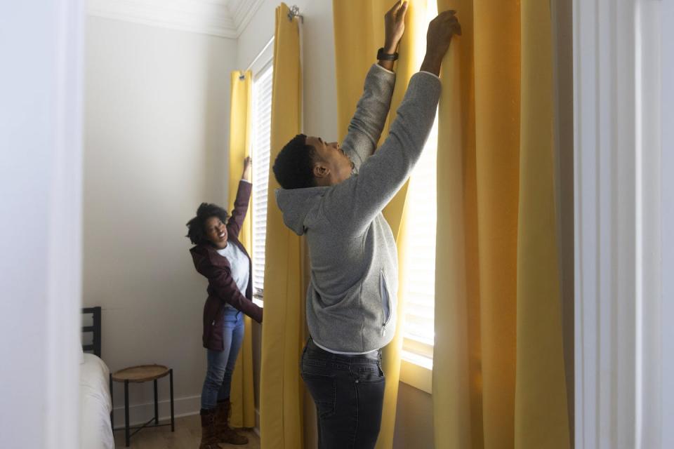 Curtains and double-glazed windows can reduce uncomfortable levels of radiant heat. <a href="https://www.gettyimages.com/detail/photo/an-african-american-stand-near-the-bedroom-windows-royalty-free-image/1446923585" rel="nofollow noopener" target="_blank" data-ylk="slk:Mireya Acierto/Photodisc via Getty Images;elm:context_link;itc:0;sec:content-canvas" class="link ">Mireya Acierto/Photodisc via Getty Images</a>