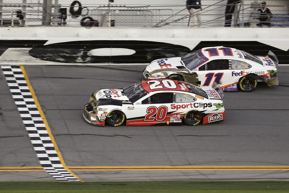 Erik Jones (20) heads to the finish line to win the NASCAR Busch Clash auto race at Daytona International Speedway, Sunday, Feb. 9, 2020, in Daytona Beach, Fla. Denny Hamlin (11), who was a lap down, helped Jones with a push in Turn 4. (AP Photo/John Raoux)