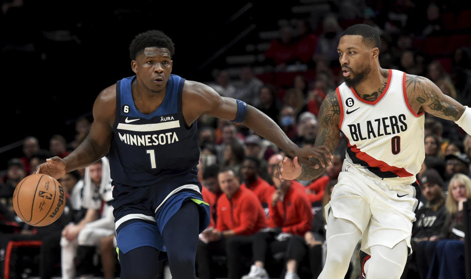 Minnesota Timberwolves guard Anthony Edwards, left, brings the ball up the court on Portland Trail Blazers guard Damian Lillard, right, during the first half of an NBA basketball game in Portland, Ore., Monday, Dec. 12, 2022. (AP Photo/Steve Dykes)