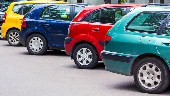 several multicolored cars parked diagonally at parking lot in the street.