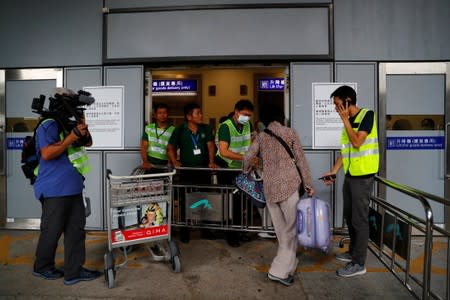 Airport officials help a passenger get inside the Hong Kong International Airport, in Hong Kong