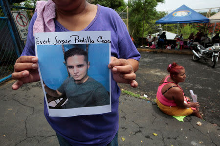 A woman stands outside a jail while holding a photograph of her son who was detained during recent protests, in Managua, Nicaragua June 16, 2018. REUTERS/Oswaldo Rivas NO RESALES. NO ARCHIVES.