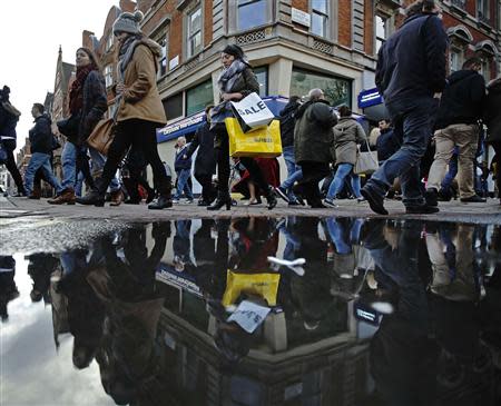 Shoppers walk along Oxford Street on the last Sunday before Christmas in London December 22, 2013. REUTERS/Luke MacGregor
