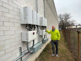 Parkway Honda partner Mark C. Mears stands beside equipment installed as part of the Dover dealership's solar power system.