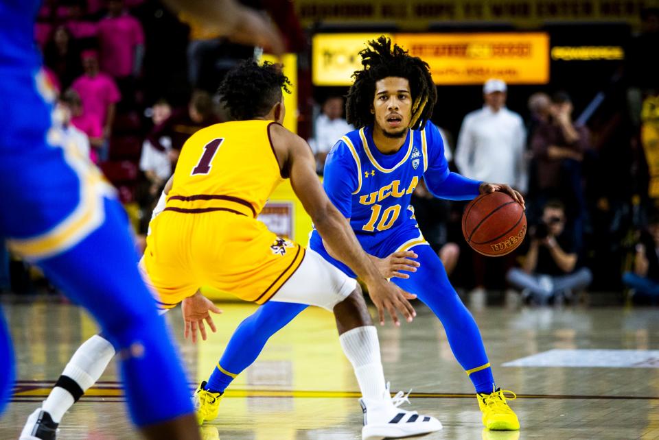 UCLA guard Tyger Campbell dribbles the ball as Arizona State guard Remy Martin defends during an NCAA basketball game between Arizona State and UCLA at Desert Financial Arena in Tempe on Thursday, Feb. 6, 2020.