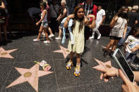 Fan Isabella Ramos, 8, from Ecuador, roller-skates next to the star of actor Olivia Newton-John on her Hollywood Walk of Fame star in Los Angeles, Monday, Aug. 8, 2022. Olivia Newton-John, the Grammy-winning superstar who reigned on pop, country, adult contemporary and dance charts with such hits as "Physical" and "You're the One That I Want" has died. She was 73. (AP Photo/Damian Dovarganes)