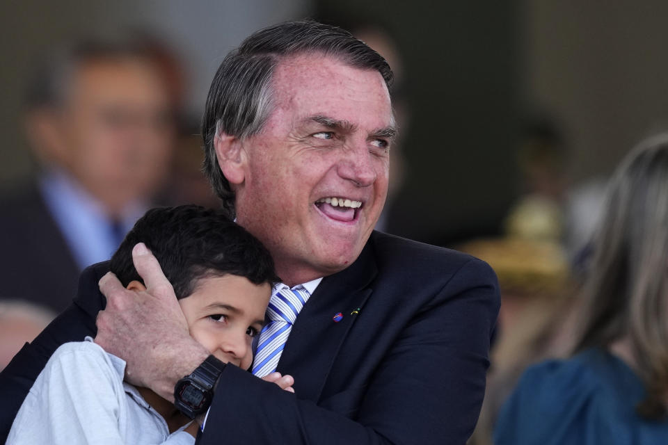 Brazilian President Jair Bolsonaro embraces a youth during a ceremony marking Soldier's Day at the Army headquarters in Brasilia, Brazil, Thursday, Aug. 25, 2022. (AP Photo/Eraldo Peres)