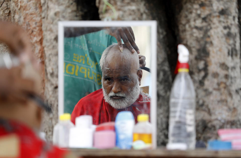 A Hindu devotee gets a tonsure to perform "Pind Daan" rituals at Sangam in Prayagraj in the northern Indian state of Uttar Pradesh India, Wednesday, Sept. 16, 2020. Pind Daan rituals are performed to bring peace and salvation to the souls of deceased ancestors. (AP Photo/Rajesh Kumar Singh)