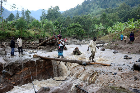 Residents cross the Sume river after a landslide rolled down the slopes of Mt. Elgon, Uganda, October 12, 2018. REUTERS/Newton Nambwaya