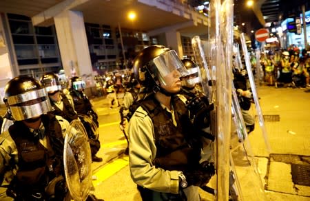 Riot police hold their shields outside Mong Kok police station in Hong Kong