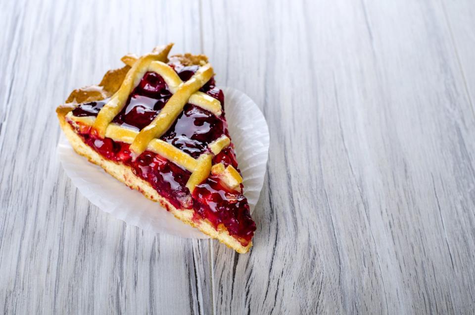 a piece of cherry pie on a wooden surface