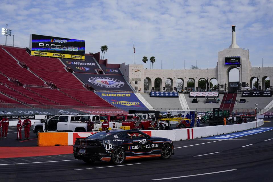 A pace car driven by NASCAR driver Daniel Suarez with LAFC's Chico Arango in the passenger seat makes it's way around the track ahead of a NASCAR exhibition auto race at Los Angeles Memorial Coliseum, Friday, Feb. 3, 2023, in Los Angeles. (AP Photo/Ashley Landis)