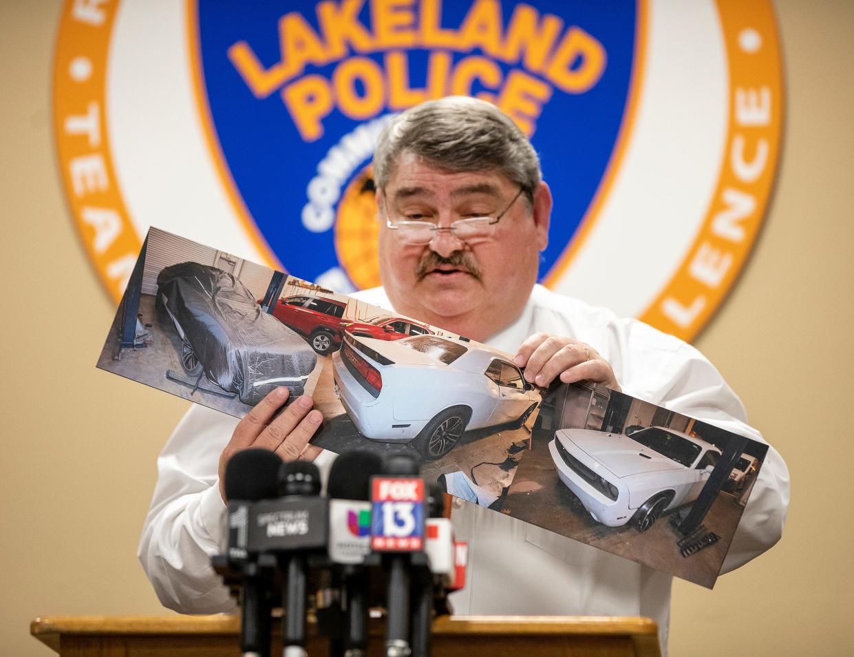 Lakeland Police Chief Sam Taylor holds a photo of a white 2014 Dodge Challenger involved in a shooting that killed two people, including a 3-year-old boy, in March.