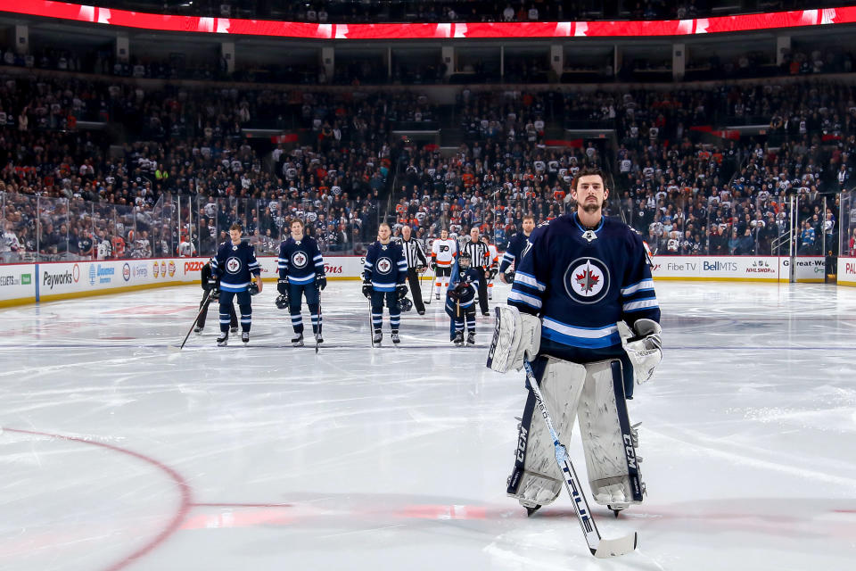 Goaltender Connor Hellebuyck #37 of the Winnipeg Jets stands on the ice during the singing of ‘O Canada’ prior to NHL action against the Philadelphia Flyers at the Bell MTS Place on December 9, 2018 in Winnipeg, Manitoba, Canada. (Photo by Jonathan Kozub/NHLI via Getty Images)