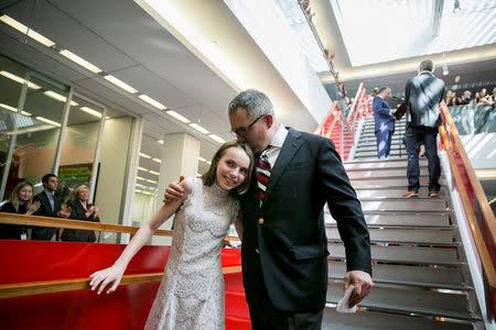 C.J. Chivers embraces his daughter, Elizabeth, 13, during a gathering of the newsroom at The New York Times for the announcement of the 2017 Pulitzer Prizes, in New York, U.S., April 10, 2017. Sam Hodgson/Courtesy The New York Times/Handout via REUTERS