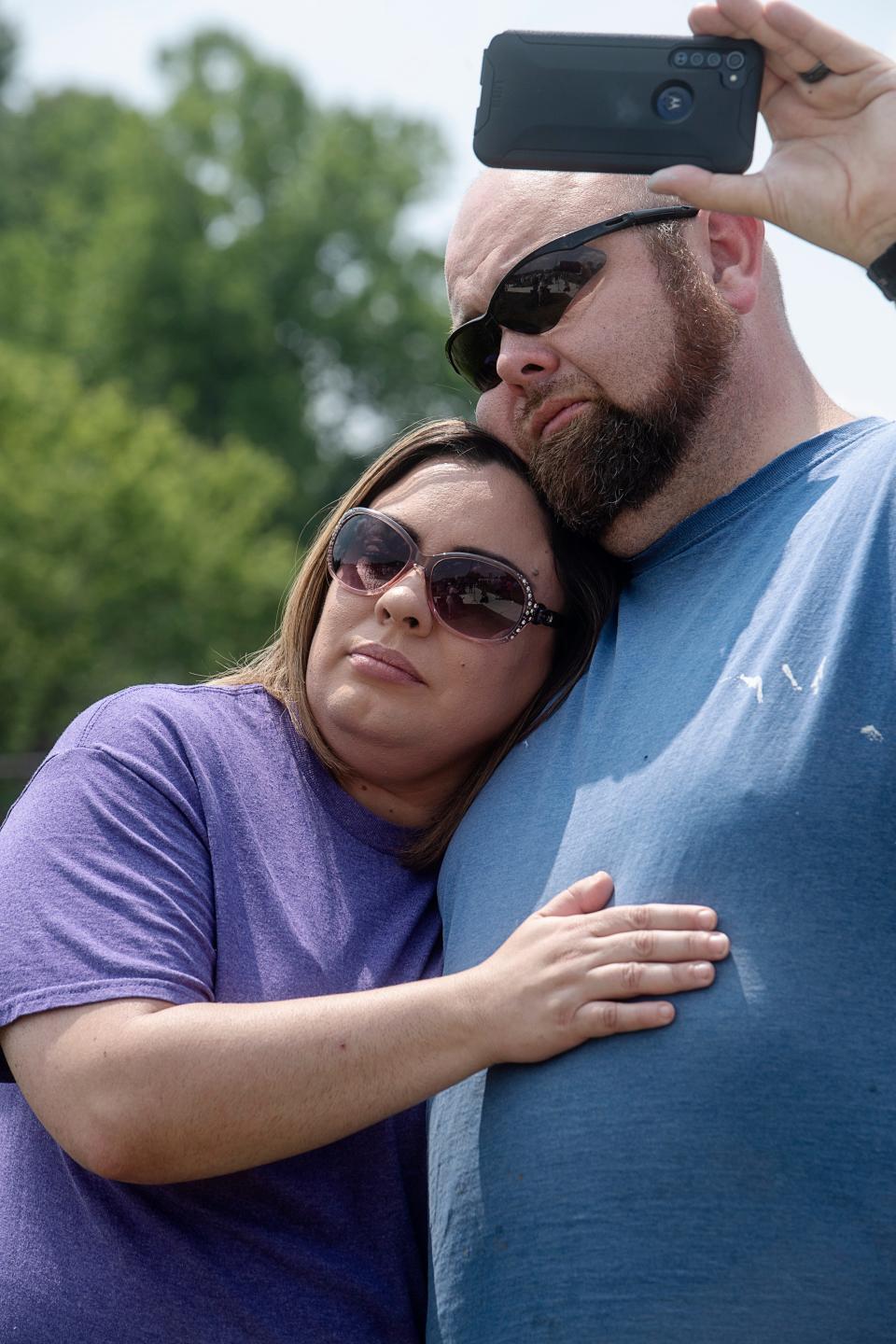Josh Scott, a fourth generation mill worker, is held by his wife, Brooke, as they listen to the final shift bell across from Evergreen Packaging at Sorells Park May 24, 2023. “I feel like my granddaddy’s dying all over again,” said Scott, who likened the final shift whistle to the plant “flatlining.”