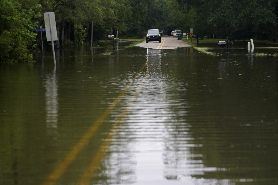 A car stops in front of neighborhood flooding after Tropical Storm Claudette passed through, in Slidell, La., Saturday, June 19, 2021. The National Hurricane Center declared Claudette organized enough to qualify as a named storm early Saturday, well after the storm's center of circulation had come ashore southwest of New Orleans. (AP Photo/Gerald Herbert)