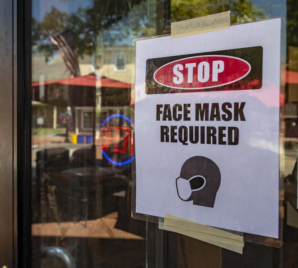 A Face Mask Required sign is posted on the front window at Francescos Pizzeria Ristorante in Burlington City.