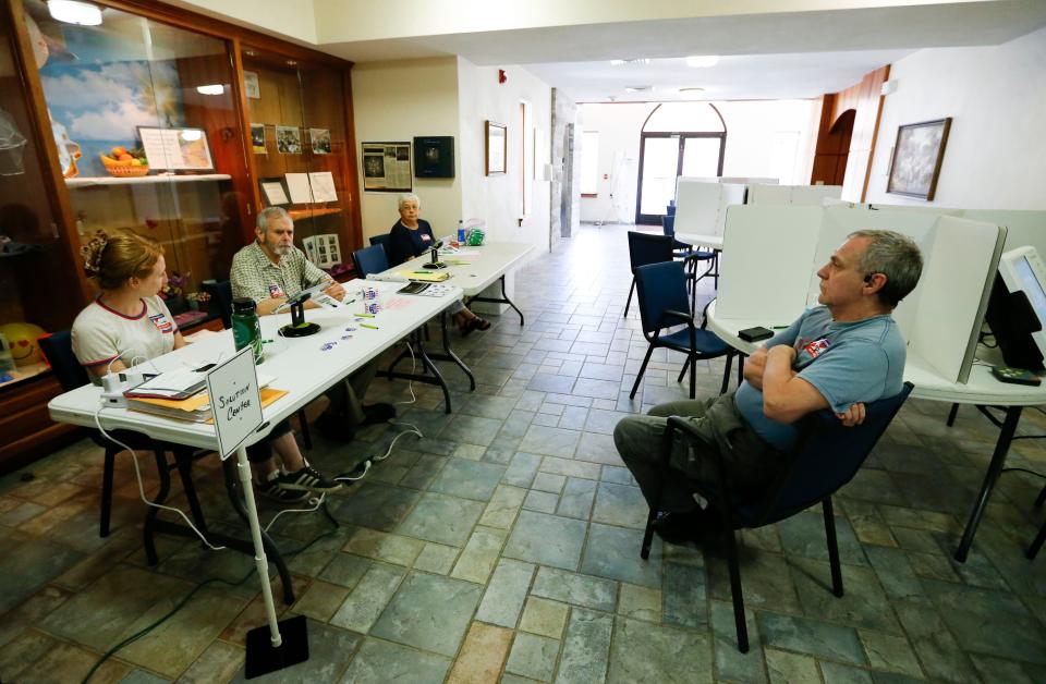 Election judges relax as they wait for voters during a municipal election with one issue on the ballot on Tuesday, Aug. 8, 2023.