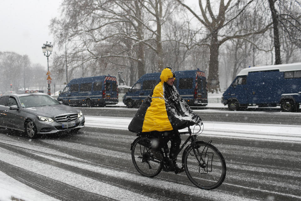 A man rides his bicycle during snowfall in Paris, Tuesday Jan.22, 2019. (AP Photo/Thibault Camus)