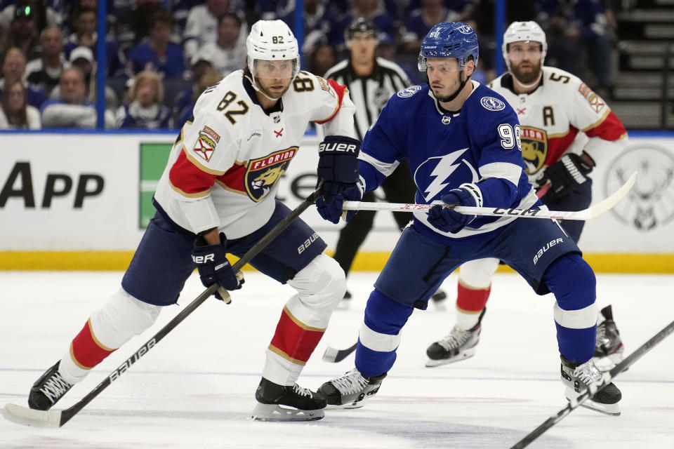 Tampa Bay Lightning defenseman Mikhail Sergachev (98) stops Florida Panthers center Kevin Stenlund (82) during the first period in Game 4 of an NHL hockey Stanley Cup first-round playoff series, Saturday, April 27, 2024, in Tampa, Fla. (AP Photo/Chris O'Meara)